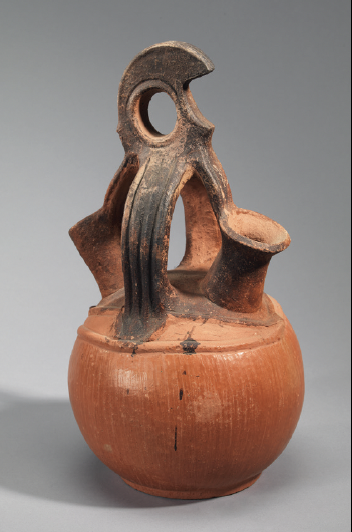 ancient terracotta jug with bird-shaped handle and spout in reddish-brown clay