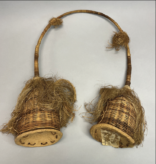 woven rattan baskets connected by a curved rattan handle with natural fiber fringes, light brown