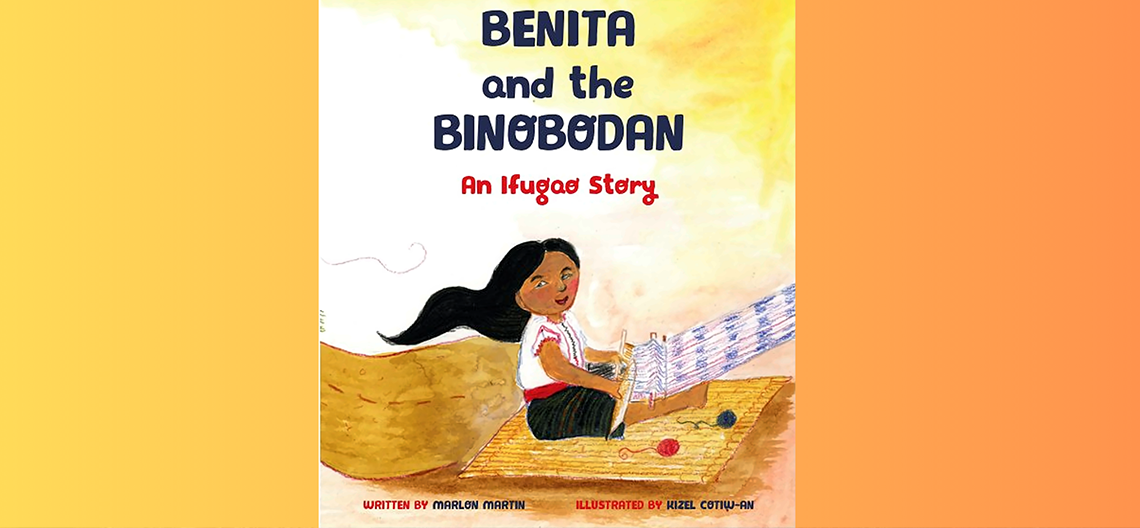 Child weaving fabric on a wooden loom sitting on a straw mat with yarn balls